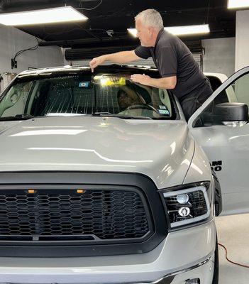 Two people working together to cut and measure the tint strip, little details matter!