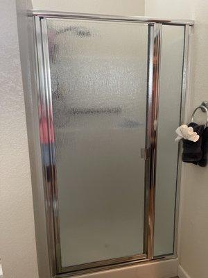 A custom cut shower door with 2023 touches to replace the warn out 25 year old door.