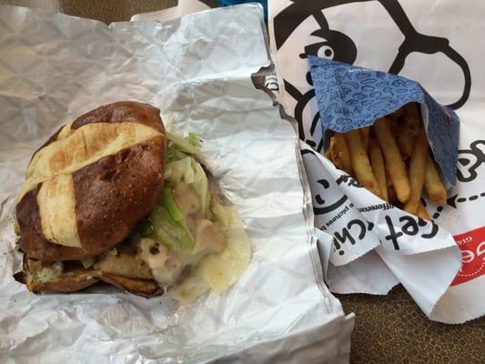 Grilled chicken pretzel sandwich and fries.