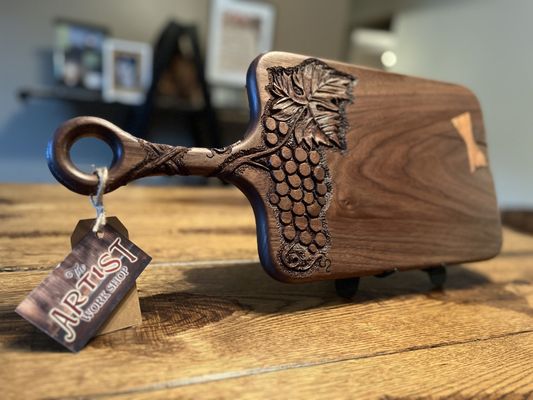 Walnut cutting board with a wild cherry bow tie and hand carved grapes