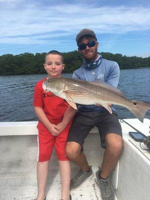 My son and Captain Larry with my son's big redfish