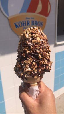 Vanilla ice cream cone dipped in chocolate and peanuts