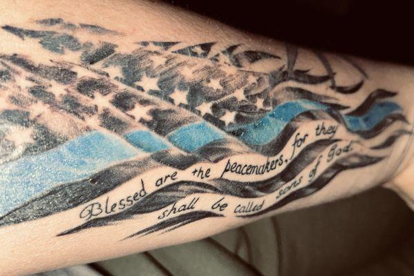 Thin blue line flag on inside of forearm.