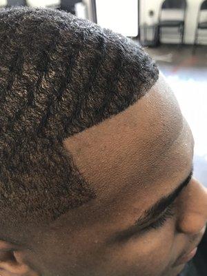 Low bald fade with wave length on top.