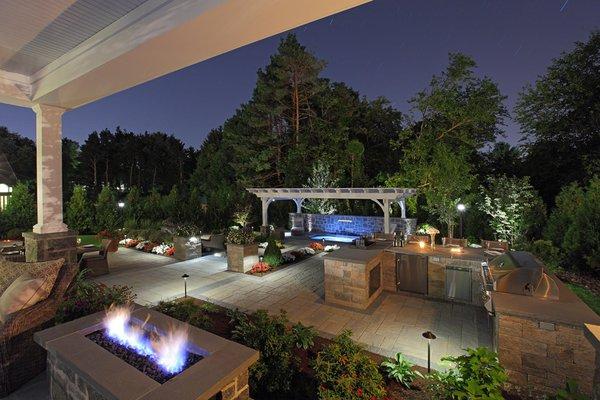 Stone patio installation with outdoor kitchen and grill.