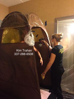 Kim Trahan spraying a client