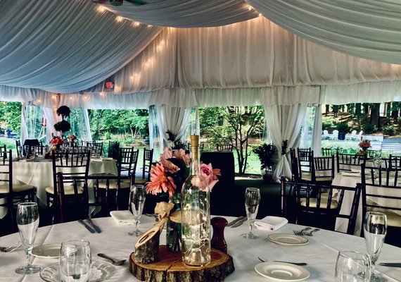 Three season tent with beautiful draping and string lights overlook the lawn and theatre.