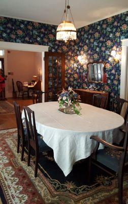 The dining room with a Victorian hanging lamp, a 1880 Walnut sideboard and Mahogany needlepoint chairs.