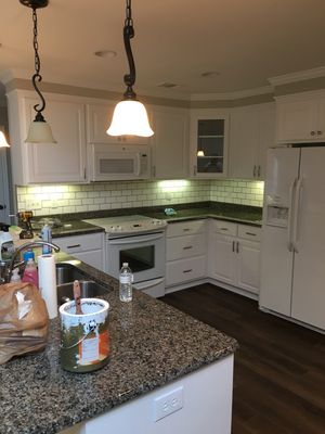 Repainted cabinets , installed tile backsplash and new flooring.