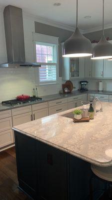 Counter tops left clean and shiny also dusted off lighting over the kitchen island