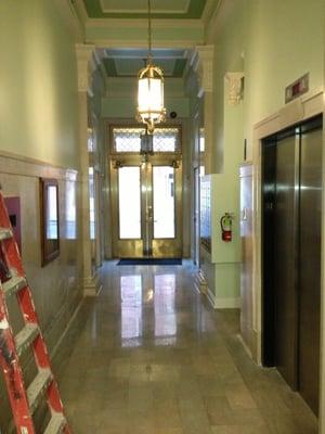 View from interior of the main hallway. The front door is locked with a with a number pad for entry.