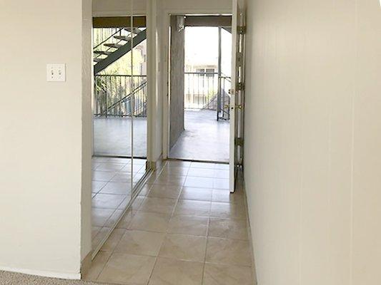 Living entry and large coat closet with mirrored doors