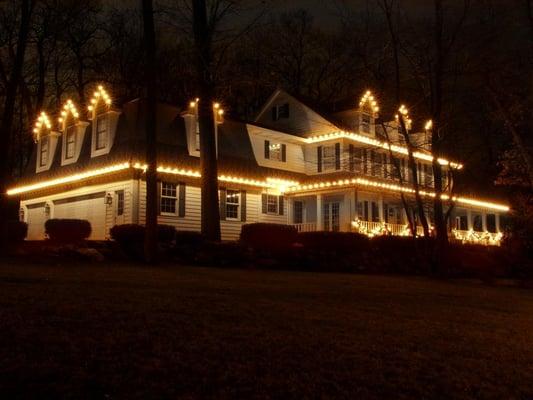 Christmas Decor - holiday lighting. Clear lights on roofline. Lit garland on front porch. Portage, MI