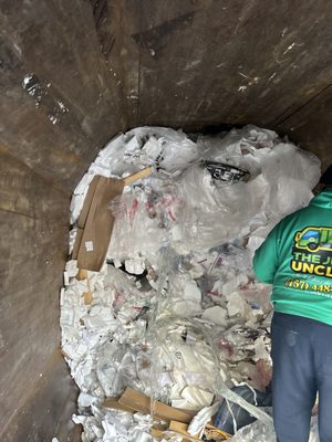 Compactor trash being taken out by hand because it was stuck in there and compactor wouldn't work until we unclogged it