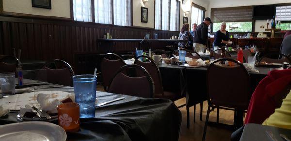 Dirty dishes on 3 rows of tables. They sat there for 45+ minutes.