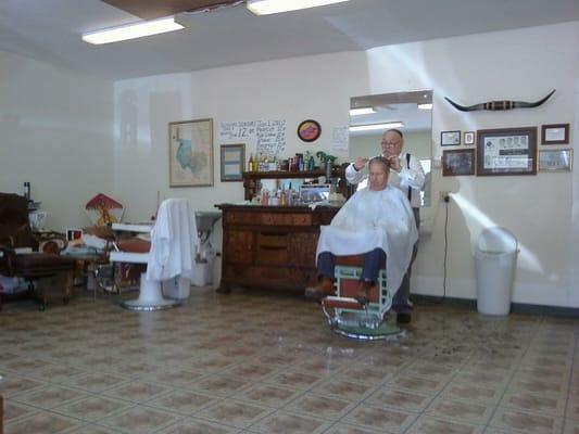 Manny giving a haircut to a customer