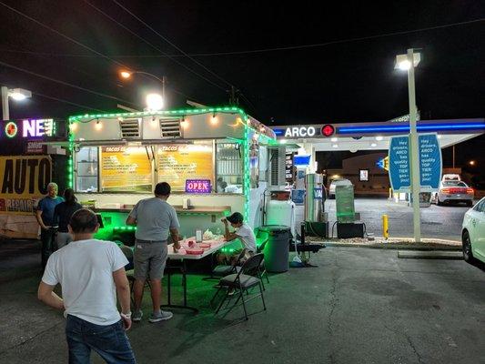 The taco truck is right in front of the Arco gas station.