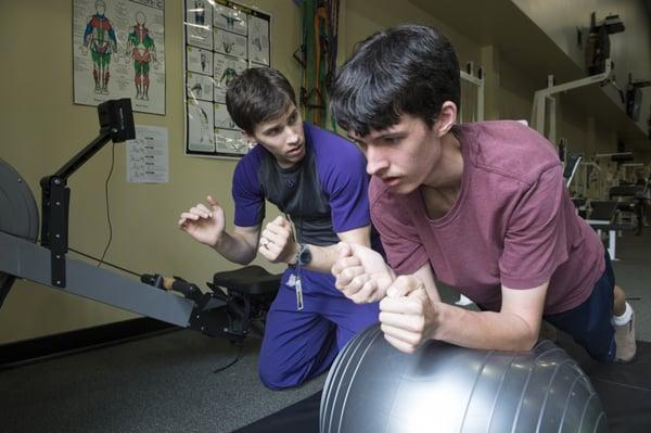 Students study physical education with personal trainers.