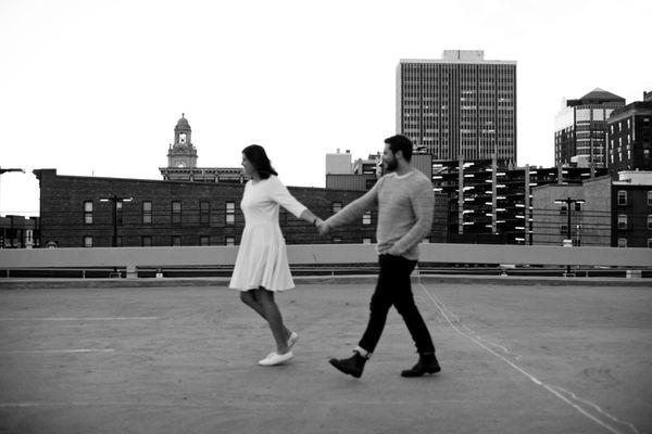 engaged couple walking on rooftop downtown des moines