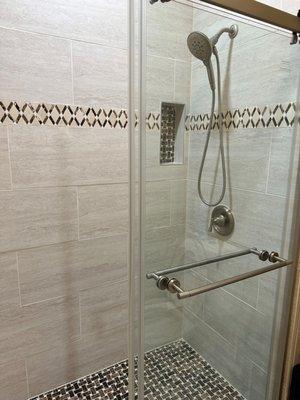 $9,999.00 Shower upgrade. Includes tile walls, new fixtures, glass shower door, and new toilet. Tile floor upgrade shown.