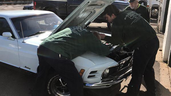 Classic 1970 Mustang Mach 1.  Pat Kinney and Son Casey adjust the carburetor.