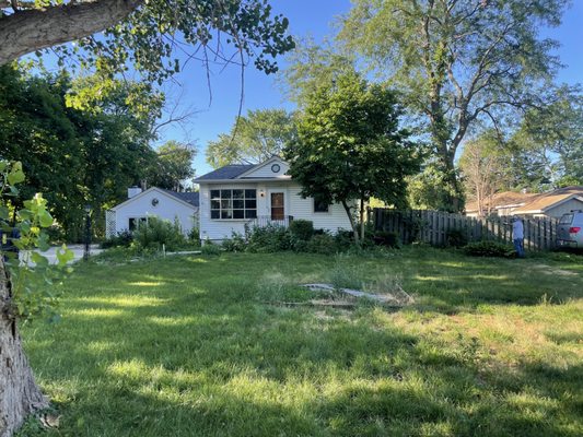 Before photo of a front yard garden bed that was cleaned up and installed with fresh mulch.