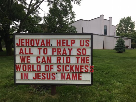 Sign by church entrance May 2020 (church building in background)