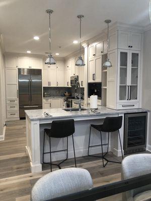 Wine cabinet over wine fridge and open shelves for cook books