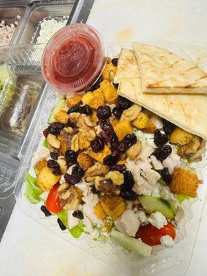 Raspberry Chicken Salad - chicken, blue cheese crumbles, walnuts, cranberries, shredded carrots, cherry tomatoes, cucumber, croutons, pita