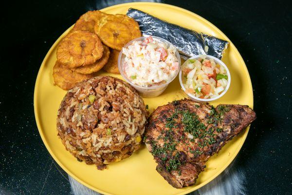 Grilled pork chop served with rice, beans, potato salad and 2 corn tortillas