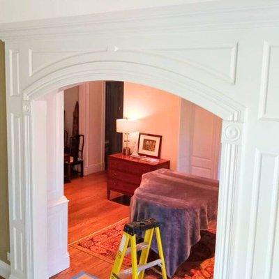 Exquisite custom millwork showcased in an elegant arched doorway, enhancing the entrance to a classically styled room.