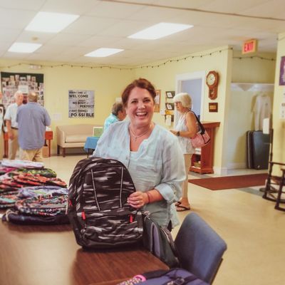 Volunteer helping stuff backpacks for kids in local transitional shelters