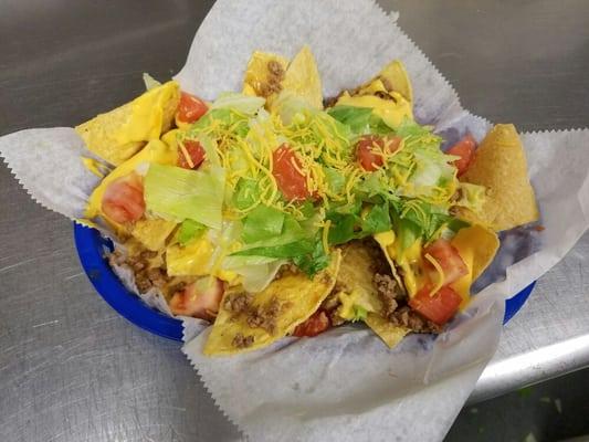 Our Beef Nachos are served on chips fried in-house, tasty taco meat, gooey nacho cheese with fresh lettuce and tomato.