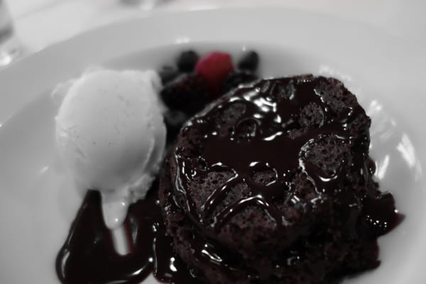 Heaven. A warm brownie topped with chocolate syrup, a scoop of vanilla ice cream, and berries.