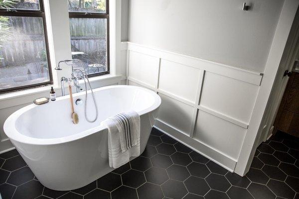 West Babylon Master Bath Remodel: new soaking tub, black floor tile, drywall Repair, paint and beadboard wainscoting.