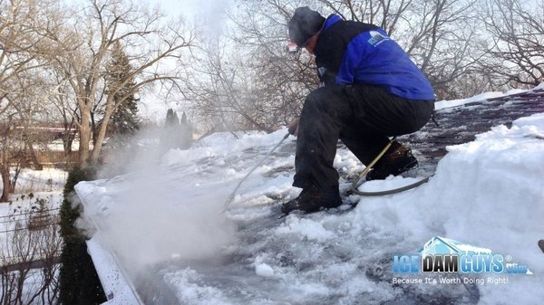 Tech for Ice Dam Guys LLC removing an ice dam on a customer's home in Milwaukee, WI.