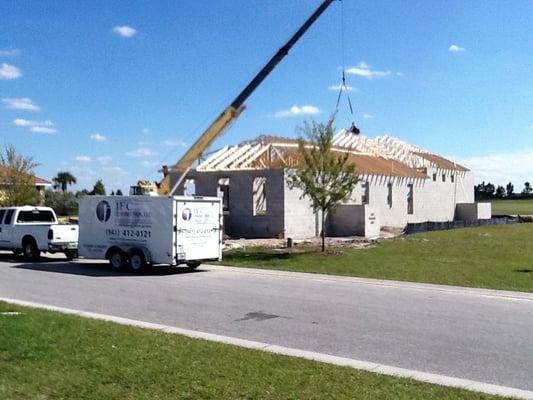 Crane setting roof trusses.