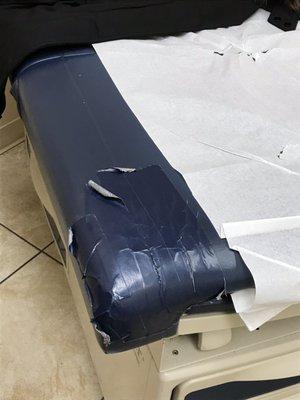 Duct taped exam table.  Holds bacteria and unacceptable.  Get a new one.   Your facility is swamped and making money.