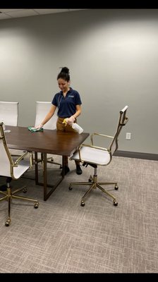 Wiping and disinfecting conference room table