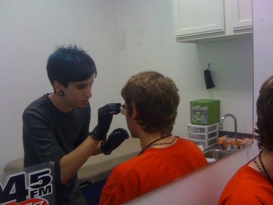 Justin piercing my friend's eyebrow.