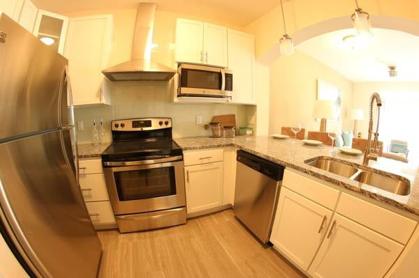 Our stunning kitchen feature Kenmore Elite stainless steel appliance, hood range, commercial grade faucet, & subway glass title backsplash!