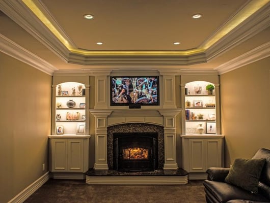 This is a media room we designed and built.  It features a custom made mantel and surround with semi-custom Canyon Creek Cabi...