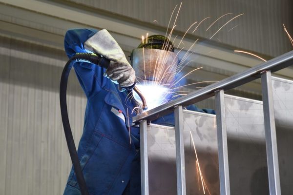 man welding steel beams together