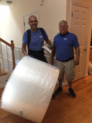 Rene and Pablo with a giant roll of bubble wrap.