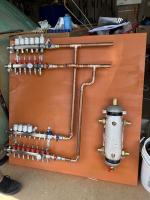 Radiant heat manifolds and hydraulic separator for installation on backer board