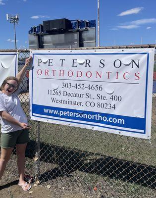 Elizabeth at the Peterson Orthodontics sign at Broomfield High School!