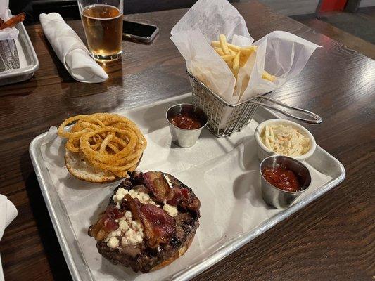 Burger on a gluten free bun with bacon, bleu cheese crumbles, onion straws and BBQ sauce on the side.