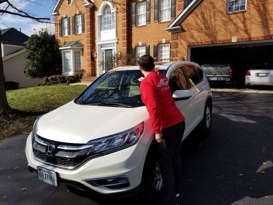 The Auto Glass Guys doing a final inspection and clean up of the new windshield before returning the vehicle to the customer.