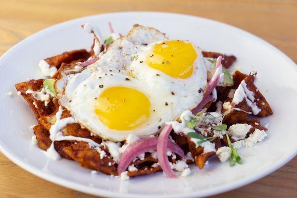 Chilaquiles: Fried corn tortilla chips tossed in a tomato and guajillo chile sauce topped with fried eggs.