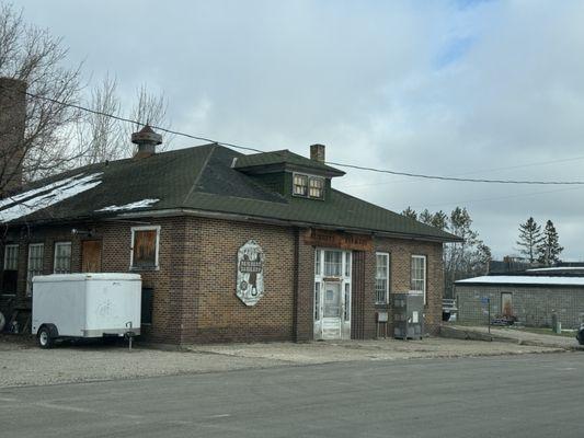 view of building from the street (note late October 2023 snow on left side of rooftop)